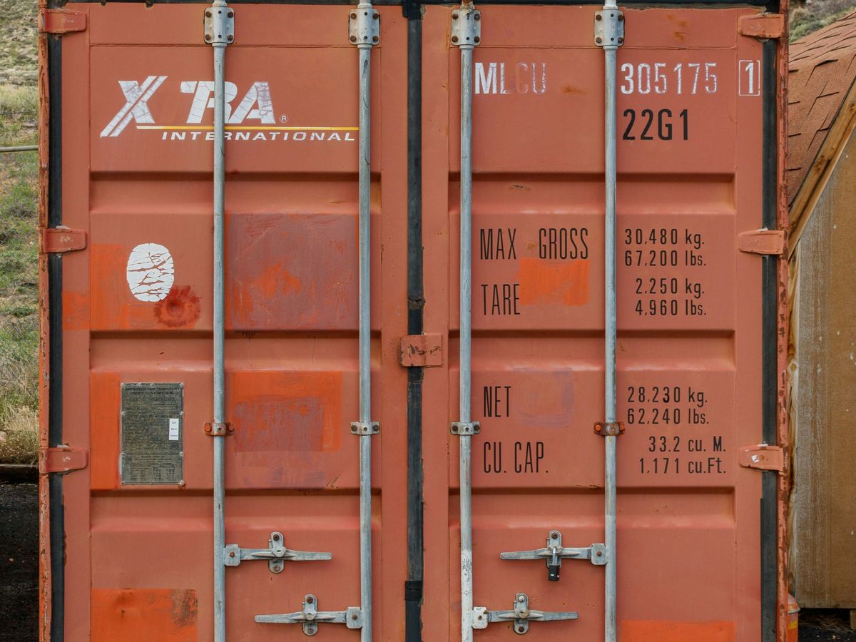 Cargo doors and locking bars on the end of an orange shipping container