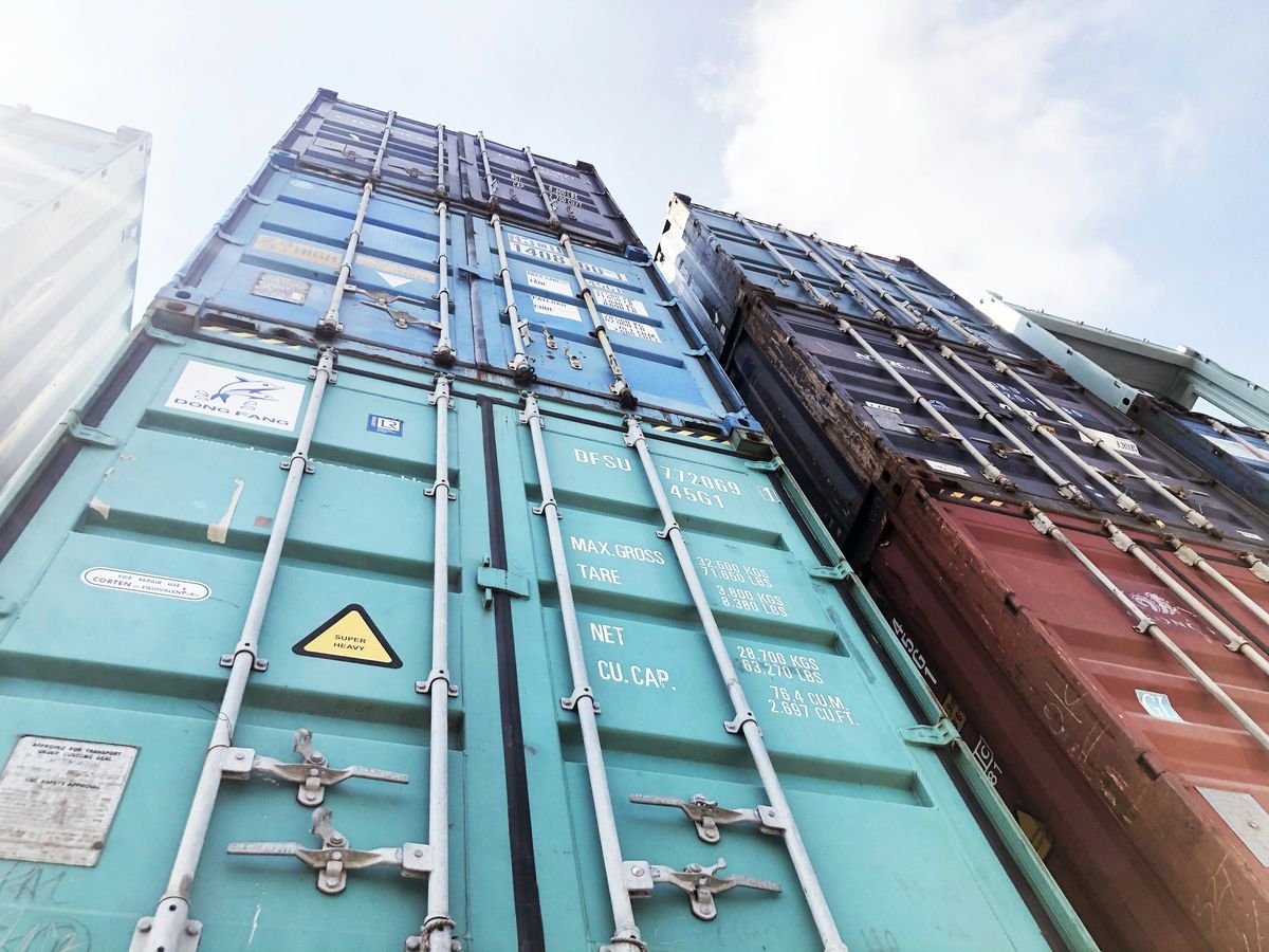 Stacks of shipping containers seen from the ground looking up