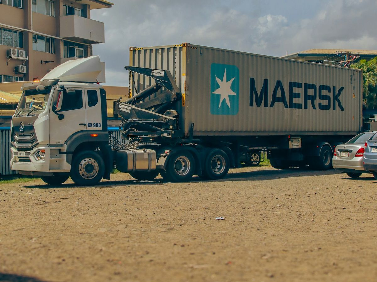 A semi truck hauling a shipping container on a trailer